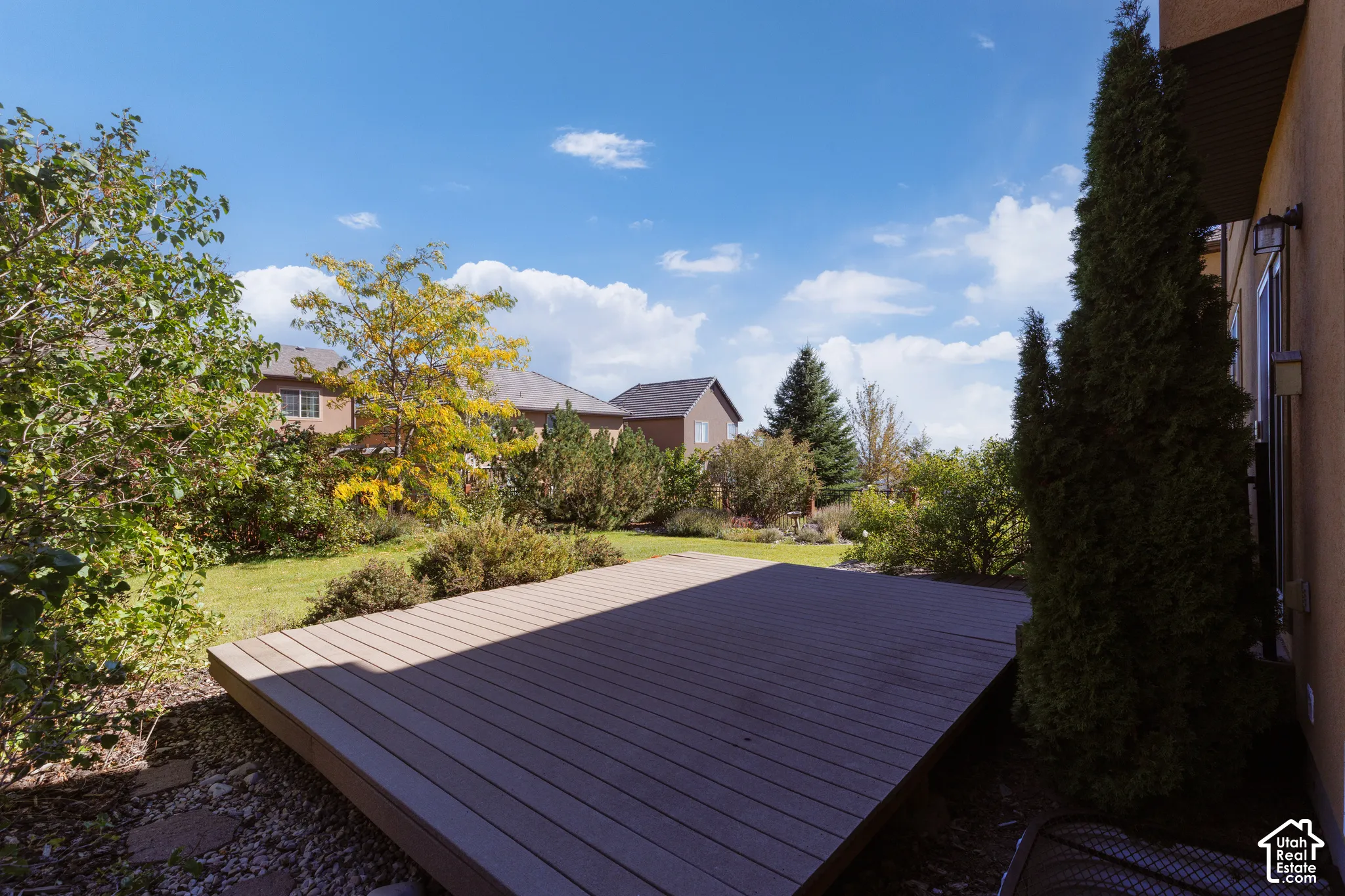Expansive wood-finish deck, mature trees, and landscaped garden area