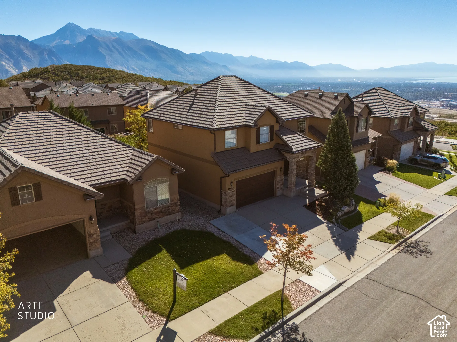 Contemporary two-story residence with a tile roof, stucco exterior, and stone accents