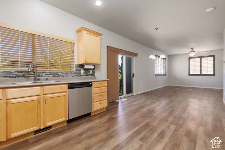 Kitchen area featuring light wood-finish cabinetry, a stainless steel sink with a gooseneck faucet, and a mosaic tile backsplash