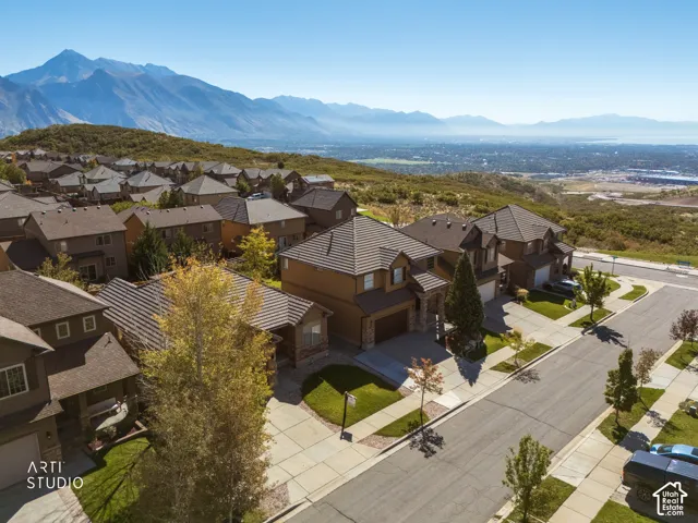 Elevated hilltop residence showcasing contemporary architectural design with brick and stone exterior, multi-level construction, and expansive hardscaped driveway