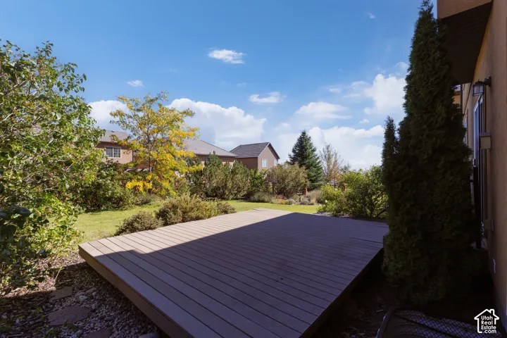 Expansive wood-finish deck, mature trees, and landscaped garden area