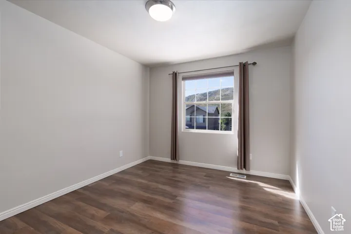 Wood-finish flooring, single window, flush-mount ceiling light fixture, white walls, and white trim