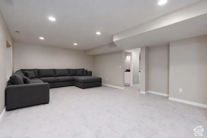 Recessed lighting, light gray carpet, neutral wall tones, and white trim accents