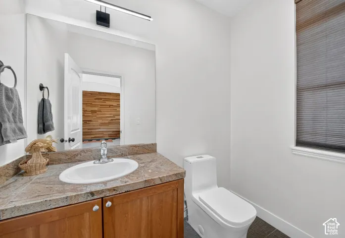 Vanity with an integrated sink, polished chrome faucet, and stone countertop