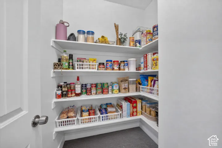 Organized pantry featuring four floating shelves with white basket organizers, ample storage for dry goods and pantry staples, and a dedicated space for small appliances and cooking supplies