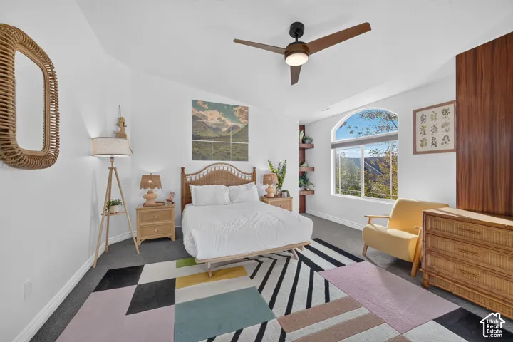 Arched window with exterior scenery, contemporary ceiling fan, and built-in shelving