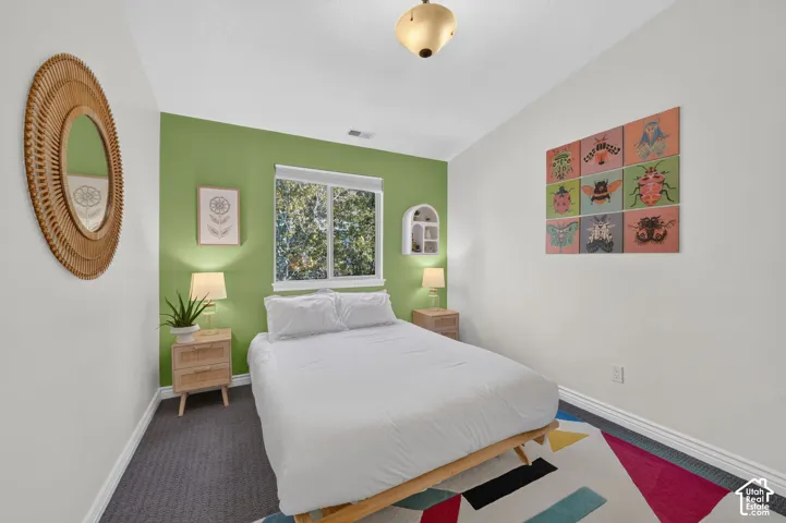 Window with exterior foliage, overhead flush-mount light fixture, and carpet flooring