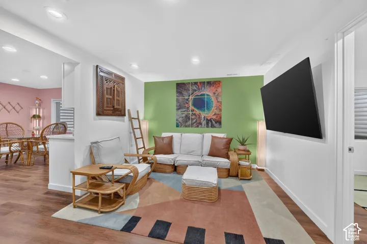 Recessed lighting, wood-finish flooring, two-tone wall paint, built-in television mount, and a wide entryway