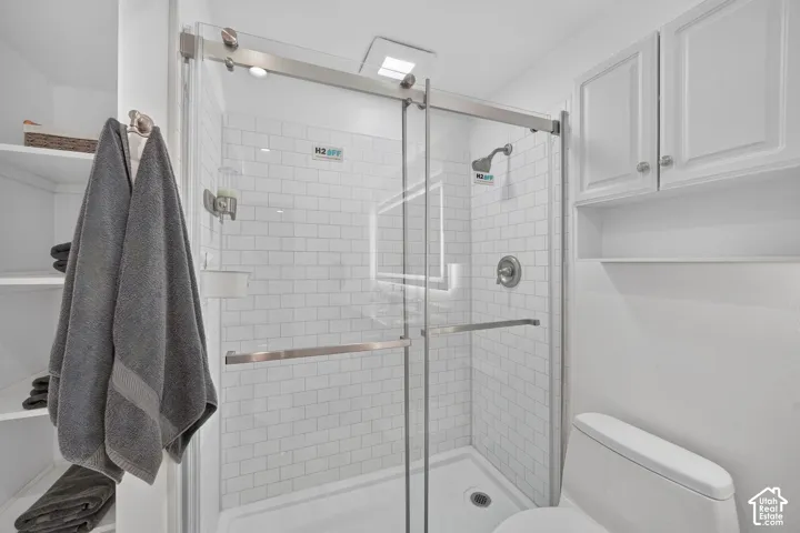 Shower with subway tile surround, glass enclosure, and brushed nickel fixtures