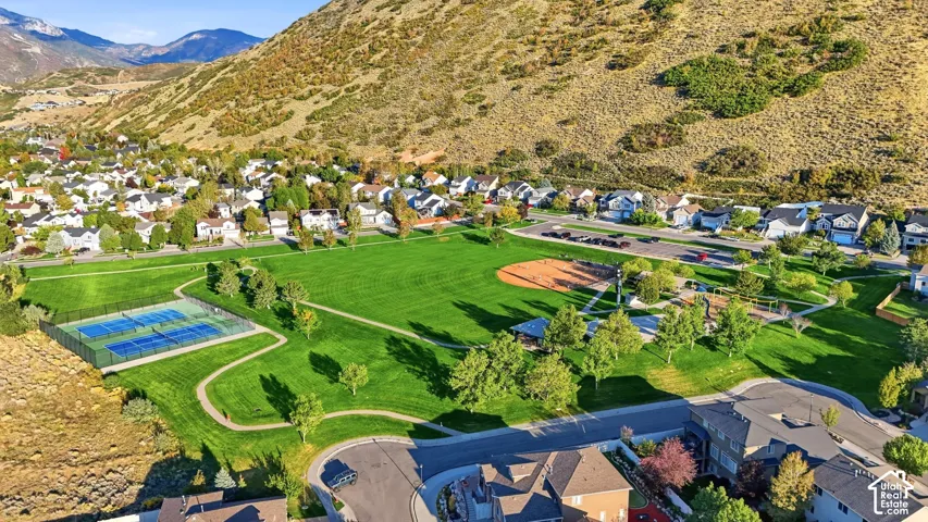 Expansive park with green spaces, tennis courts, baseball diamond, and walking paths