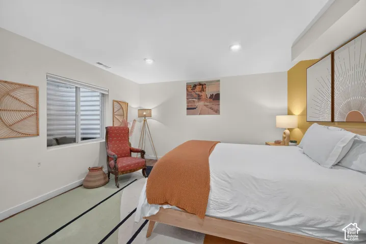 Recessed ceiling lighting, a window with horizontal blinds, and a built-in wall niche with accent lighting