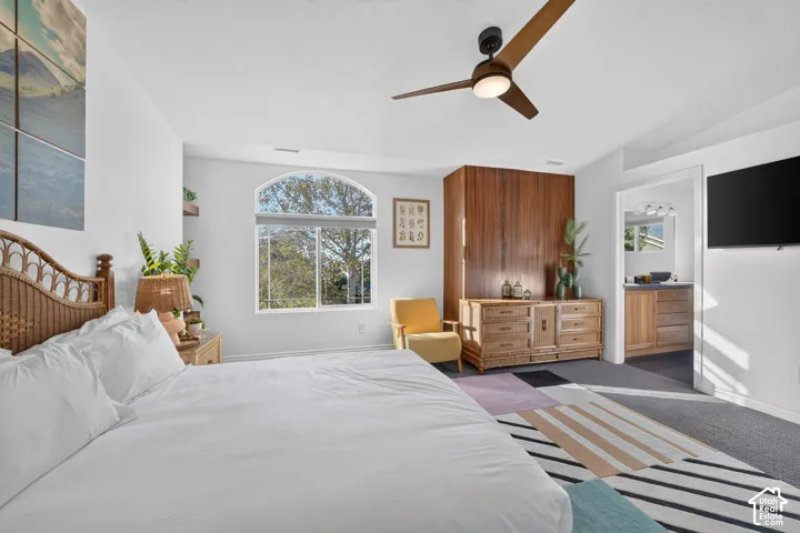 Arched window, wood-paneled accent wall, and ceiling fan with integrated lighting