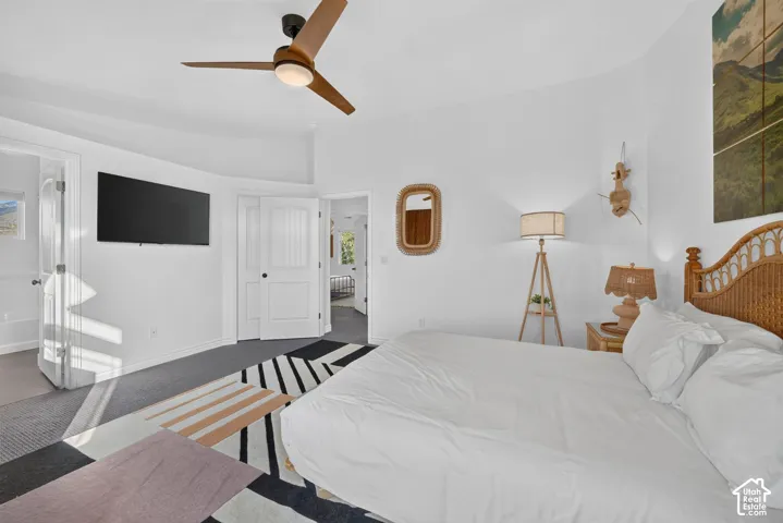 White walls with a ceiling fan featuring wood-finish blades