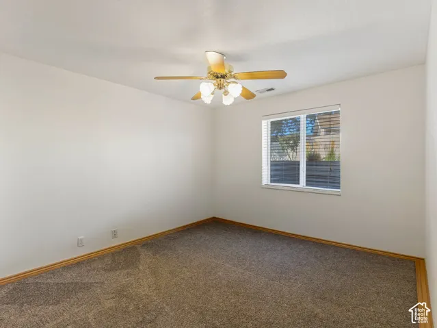Carpeted flooring, ceiling fan with integrated lighting, wood-finish trim, and window with blinds