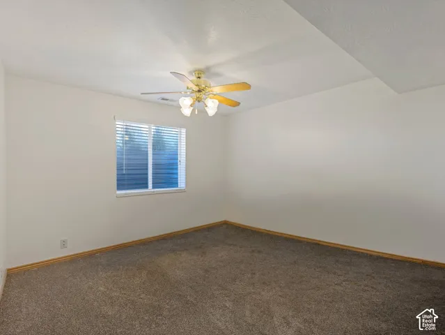 Neutral-toned carpeting, white walls, and a window with blinds