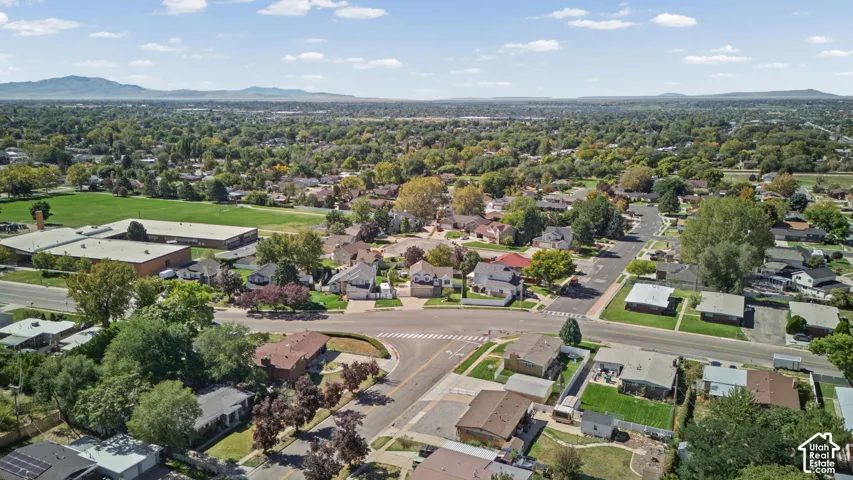 Expansive community featuring mature trees, residential properties, and paved streets