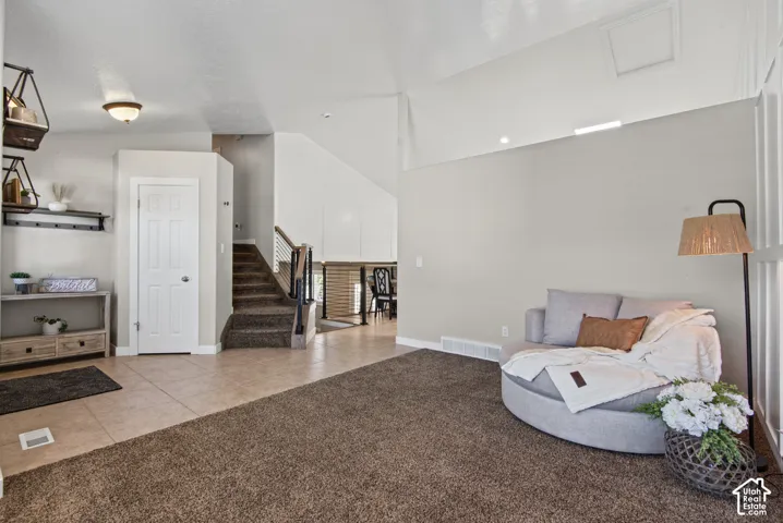 Vaulted ceilings enhance the living space, complemented by a combination of plush carpeting and tile flooring