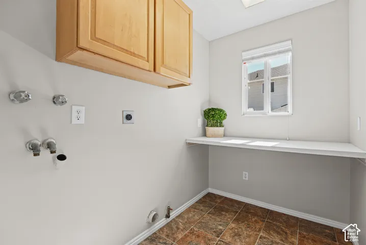Light wood-finish upper cabinetry, a built-in white countertop, and a window with white blinds