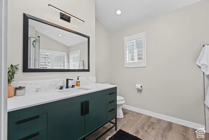 Deep green vanity with matte black hardware, white countertop, and marble-finish backsplash
