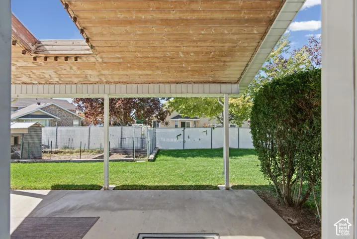 Covered patio with a wood-finish ceiling, concrete flooring, and a grass lawn