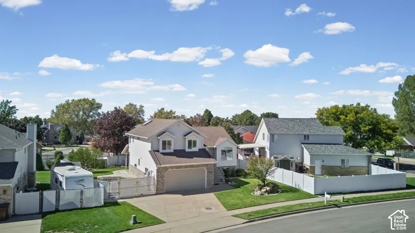Tri-level residence with a brick and siding exterior, an attached two-car garage, and a concrete driveway