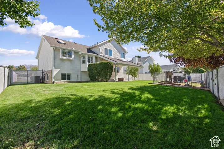 Expansive lawn area, fencing, mature trees, and covered patio