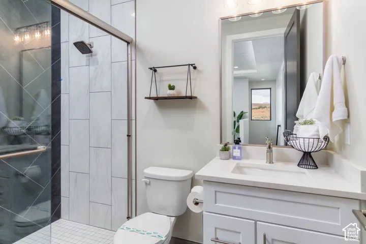 Shower with glass enclosure, white rectangular wall tiles, and a rainfall showerhead