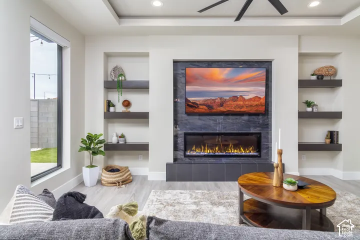 Feature wall with a linear electric fireplace, stone tile surround, and media niche