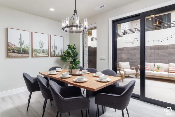 Wood-finish flooring with a modern chandelier and recessed lighting