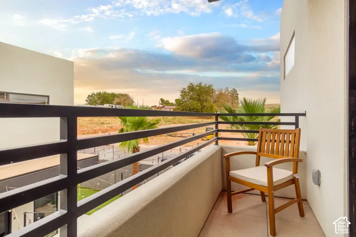 Private balcony with a dark metal railing and stucco exterior