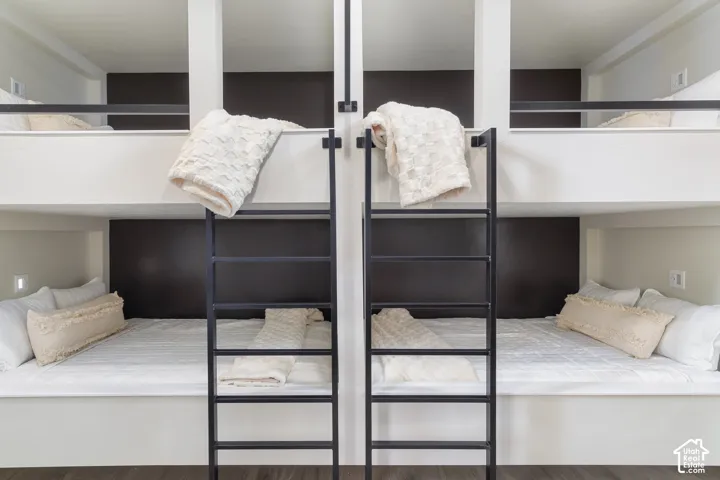 Built-in bunk beds with integrated ladders, white bedding, and dark accent walls