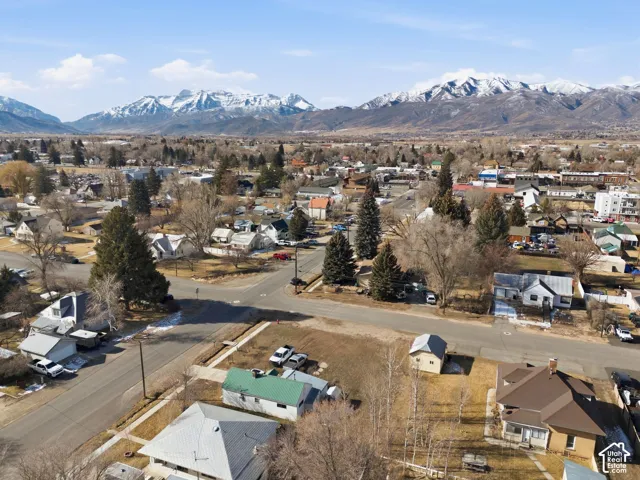 Scenic mountain backdrop, residential area, established trees, paved roads, and varied architectural styles