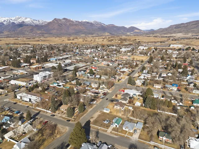 Expansive aerial perspective showcasing a residential and commercial area with mountain backdrops