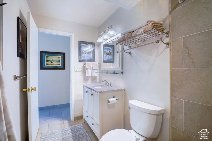 White vanity with a light-colored countertop, undermount sink, and polished chrome faucet