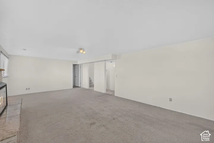 Carpeted interior with light-toned walls and a window