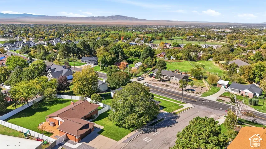 Expansive residential property featuring a manicured lawn, established landscaping, and a white privacy fence