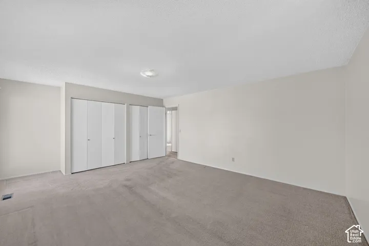 Expansive room with neutral carpeting and light-colored walls