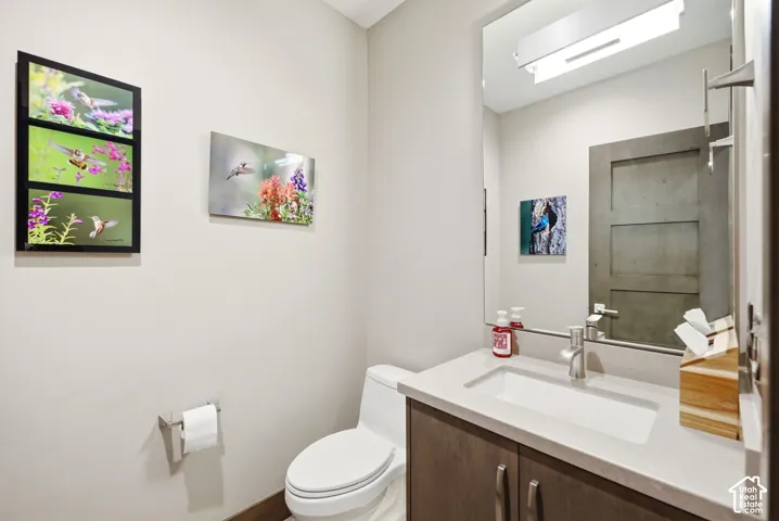 Bathroom featuring a built-in vanity with a rectangular basin, light-toned countertop, and wood-finish cabinetry