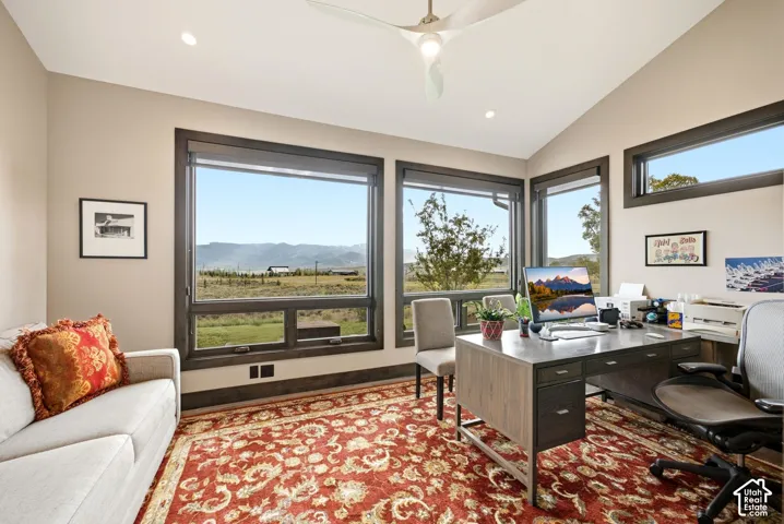 Vaulted ceiling with a contemporary ceiling fan, recessed lighting, and multiple large windows with dark trim
