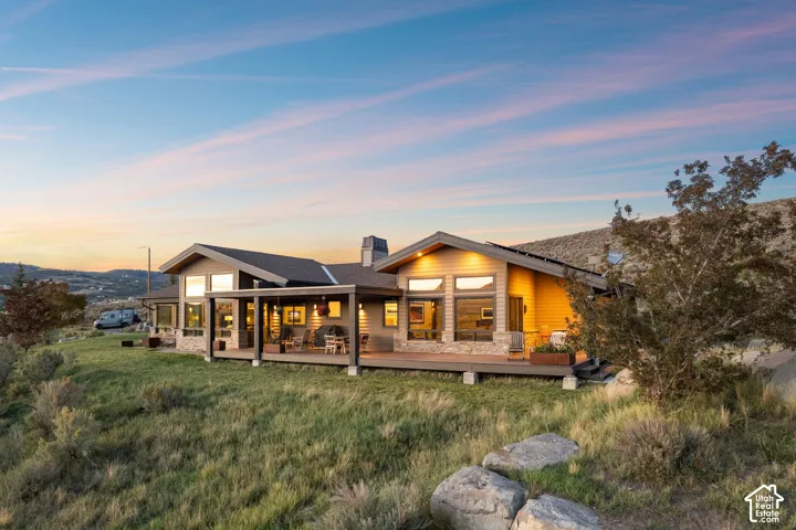 Contemporary residence featuring a covered deck, stone accents, and expansive windows