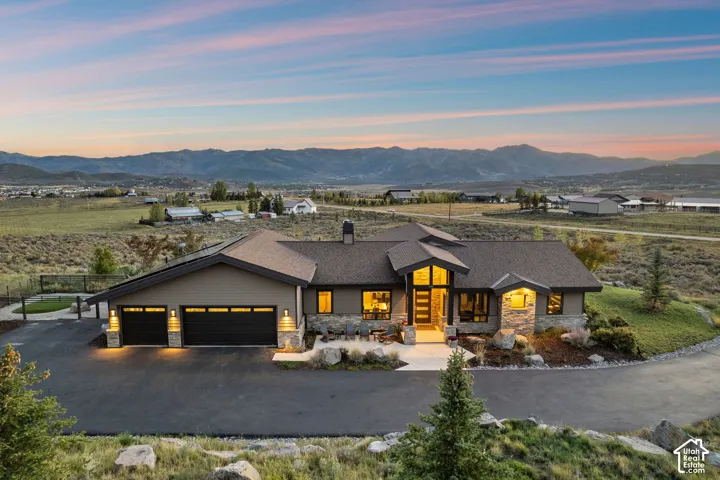Contemporary architecture featuring a multi-gabled roofline, stone accents, and a wide paved driveway