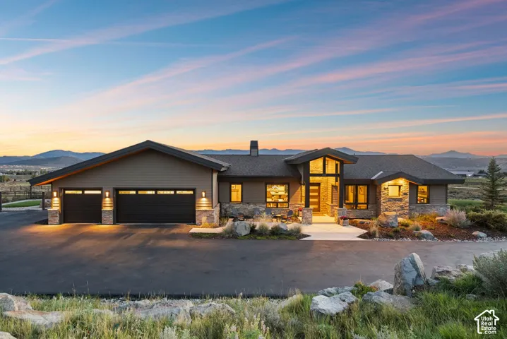 Contemporary exterior with stone accents, a multi-pane front entry, and a two-car garage