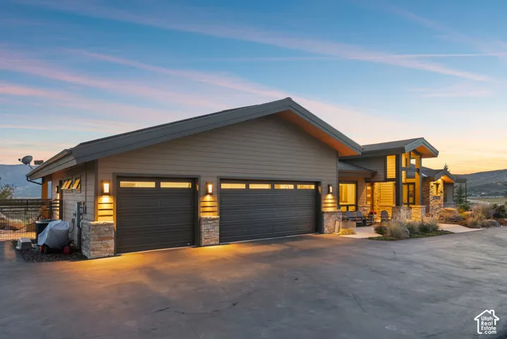Modern exterior with multi-toned siding, stone accents, and a large multi-car garage