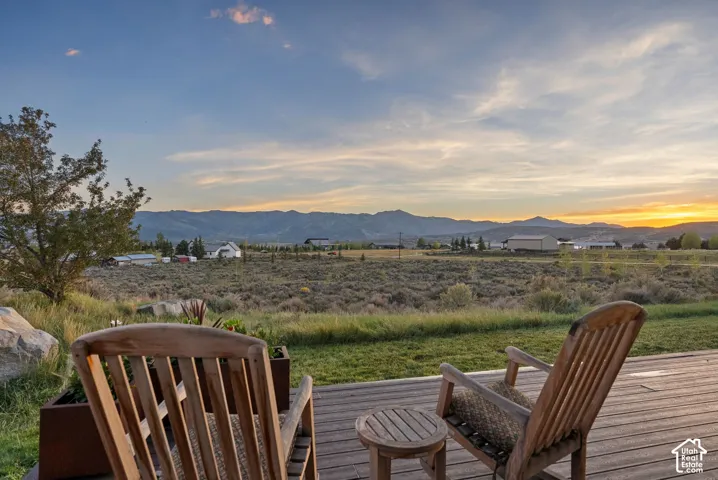 Expansive outdoor deck featuring wood planking and a broad, natural landscape with distant mountains