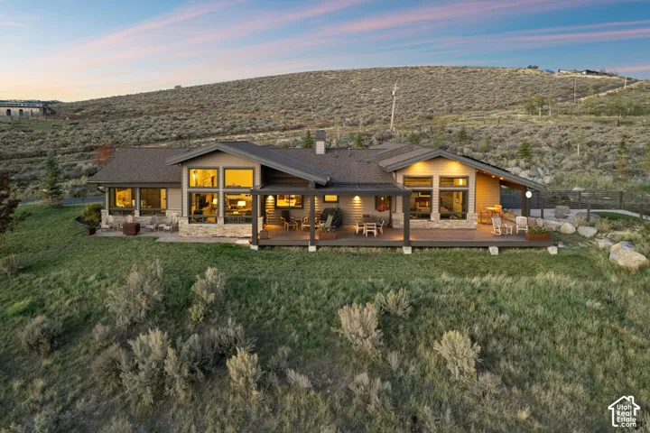 Single-story residence featuring extensive decking, large windows, and stone accents