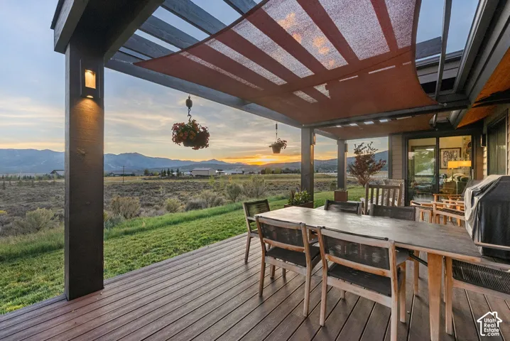 Expansive outdoor living area featuring a covered deck, wood-finish composite decking, and a red shade canopy