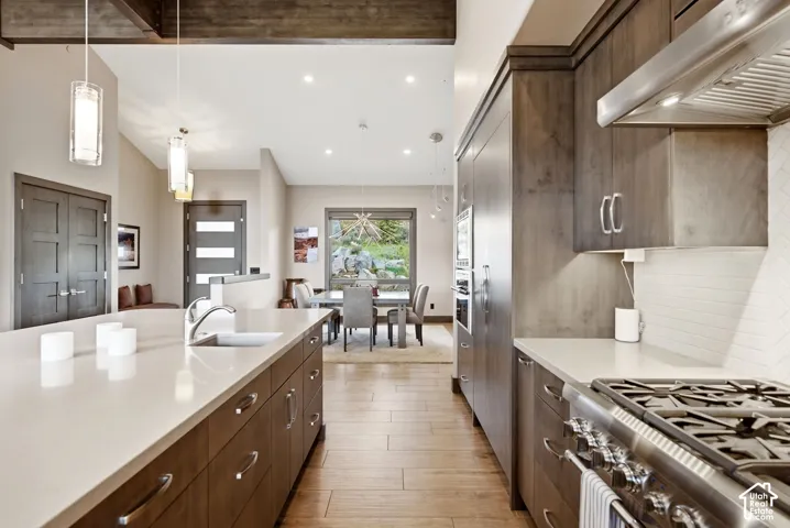 Kitchen featuring wood-finish flooring, light-toned countertops, and dark wood-finish cabinetry