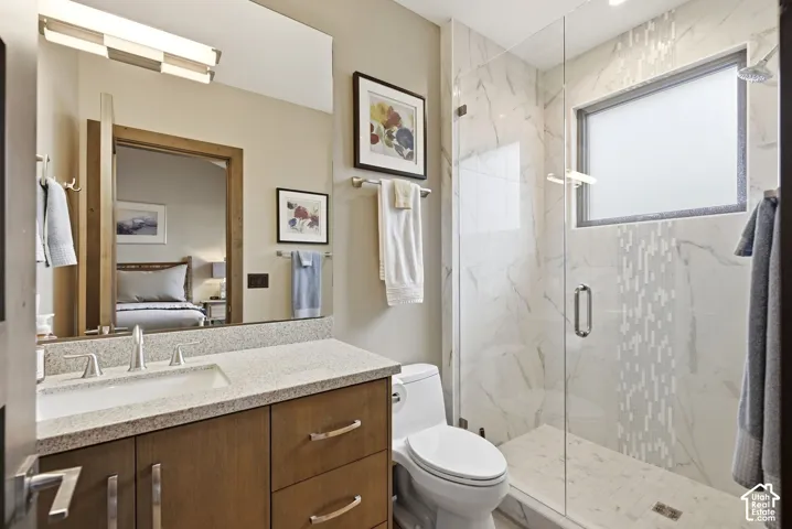 Shower with glass enclosure, marble-finish tile, and privacy window