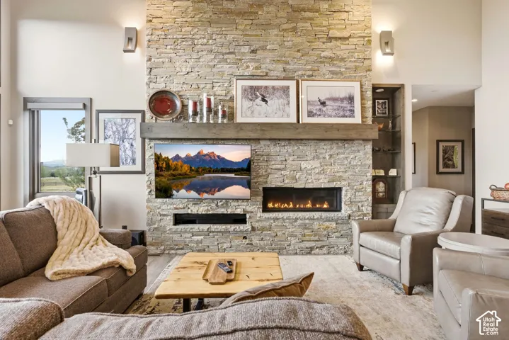 Floor-to-ceiling stacked stone fireplace with a wood mantel