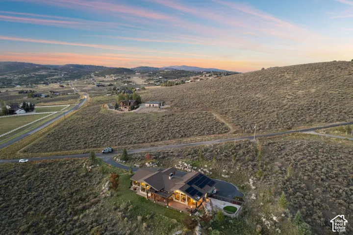 Expansive property featuring a single-story residence with a dark-tiled roof and integrated solar panels